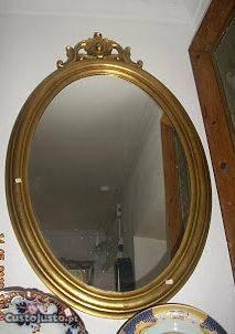 Antigo espelho oval em talha dourada